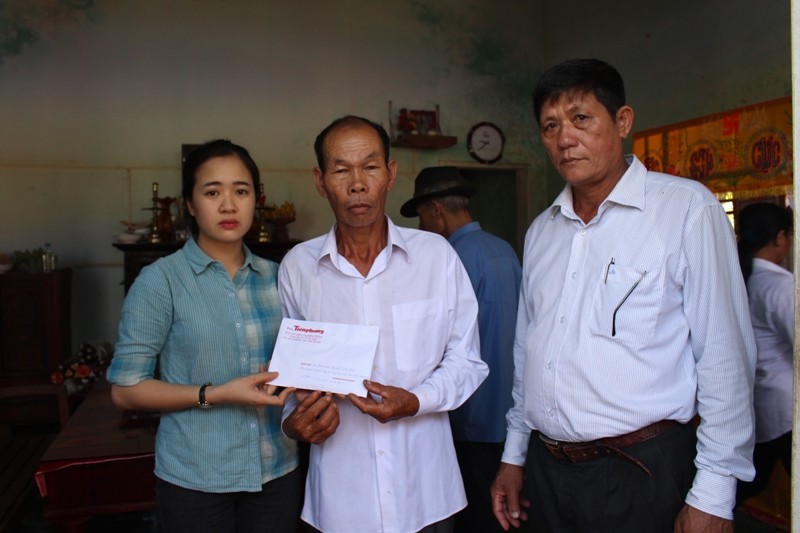 Đại diện Báo Tiền Phong trao tiền hỗ trợ cho gia đình "hiệp sĩ" Nguyễn Văn Thôi. Ảnh: Giang Thanh