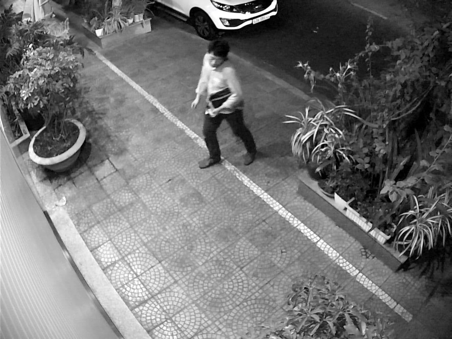 Người đàn ông Hàn Quốc đi vòng quanh xe ô tô đang đỗ trước cửa nhà ông Linh. Ảnh cắt từ camera an ninh