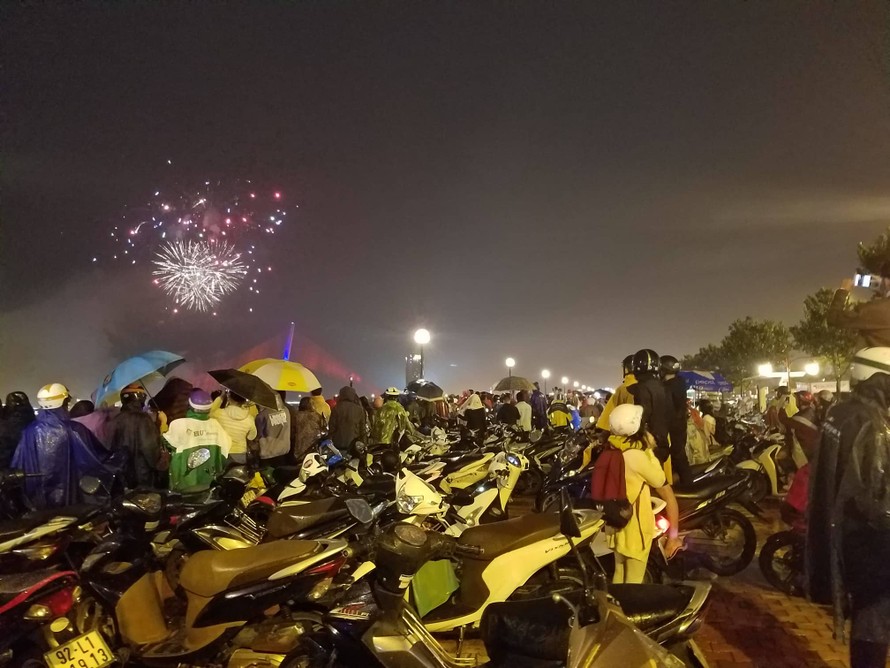 Người dân Đà Nẵng 'đội mưa' xem pháo hoa chào năm mới 2019. Ảnh: Giang Thanh