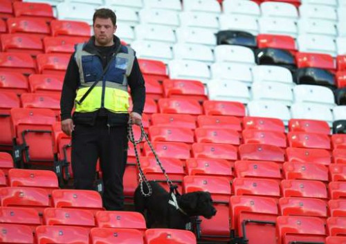 Cảnh sát và chó nghiệp vụ kiểm tra ghế ngồi tại sân Old Trafford.