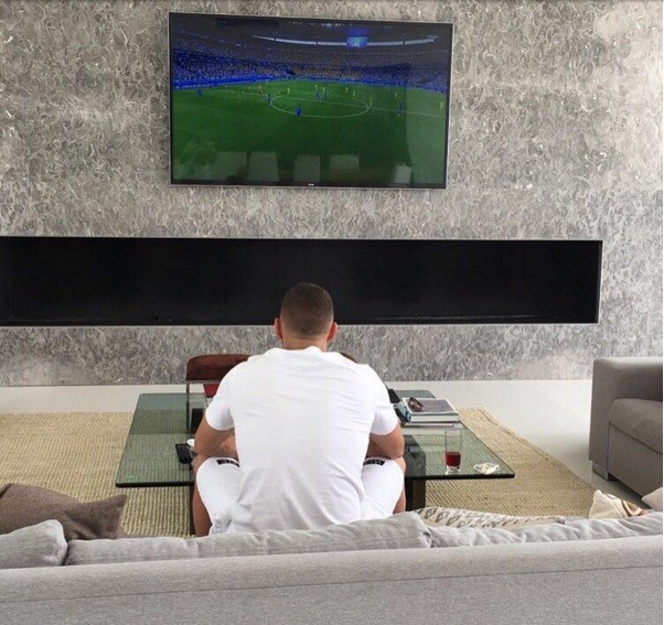 Benzema lặng lẽ theo dõi đội tuyển Pháp thi đấu qua màn hình tivi.