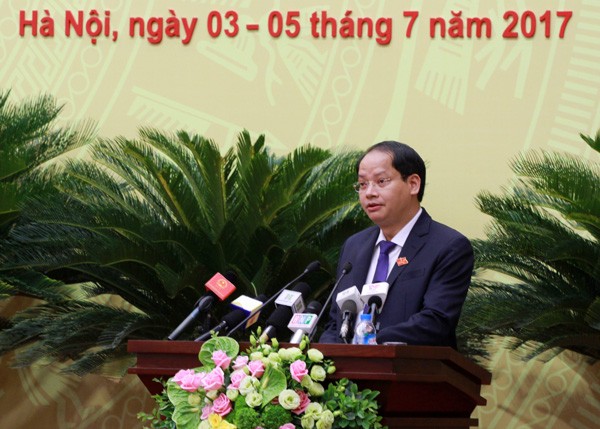 Phó Chủ tịch UBND TP Nguyễn Doãn Toản trình bày báo cáo tình hình thực hiện kinh tế - xã hội tại phiên khai mạc sáng nay