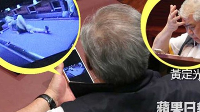  Nghị sĩ Wong Ting-kwong bị ống kính máy quay bắt được cảnh xem phim sex trên điện thoại giữa buổi họp.