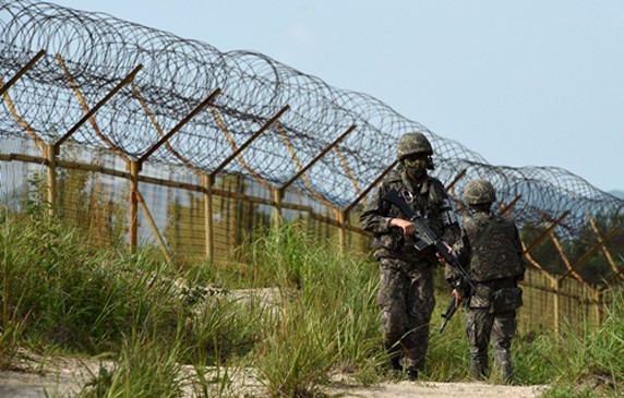 Binh sĩ Hàn Quốc tuần tra dọc hiện trường vụ nổ mìn ở khu phi quân sự (DMZ) tại thành phố Paju, Hàn Quốc, hôm 9/8. Ảnh: Reuters.