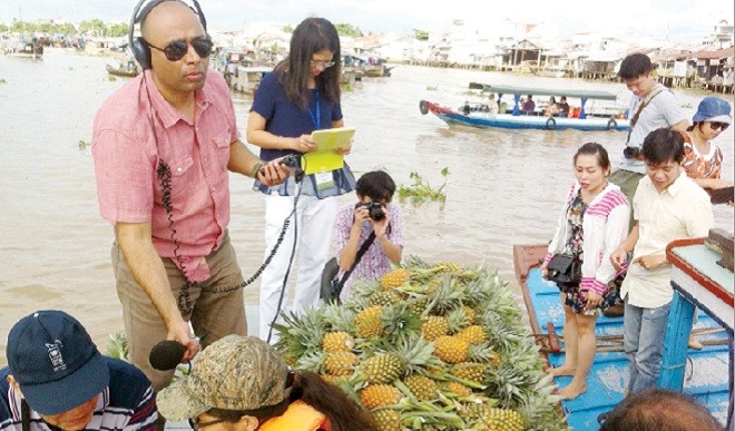 Các phóng viên trên thuyền bán khóm ở chợ nổi Cái Răng. Ảnh: Sáu Nghệ