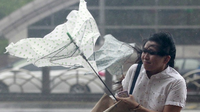 Người phụ nữ đi trong mưa và gió lớn tại Đài Bắc. Ảnh: Reuters