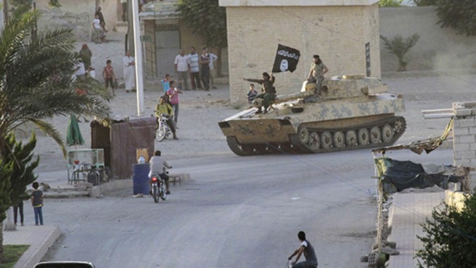 Các tay súng IS cưỡi xe tăng đi trên đường phố Raqqa. Ảnh: Reuters