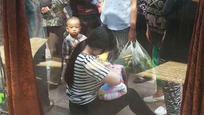 Hình ảnh người phụ nữ trẻ cho em bé bú trên vỉa hè được nhiều người ca ngợi. Ảnh: Shanghaiist.