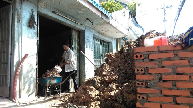 Bà Lâm Thị Thu Hương thuê người đổ đất nâng nền nhà ở đường Kinh Dương Vương chiều 1/6. Ảnh: Việt Văn