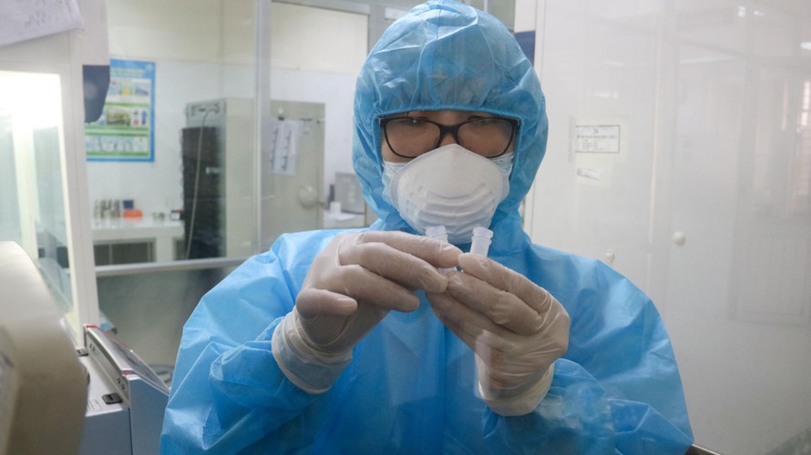 Nhân viên CDC Đà Nẵng làm việc trong phòng thí nghiệm xuyên đêm để tìm COVID-19. Ảnh: Nguyễn Thành. 