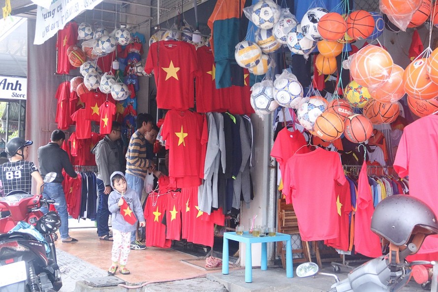Từ sáng sớm, các cửa hàng ở Đà Nẵng đã tấp nập khách mua đồ cổ vũ đội tuyển Việt Nam. Ảnh: Nguyễn Thành