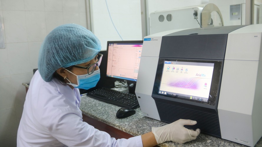 Nhân viên kỷ thuật CDC TP Đà Nẵng thao tác trên máy nhân gen, đọc kết quả Real time - PCR. Ảnh: Nguyễn Thành