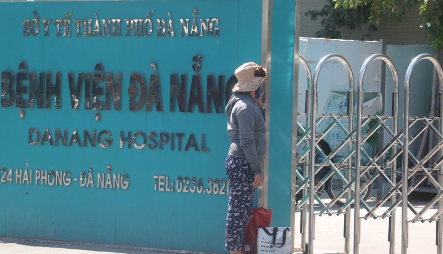 Một người nhà bệnh nhân đứng trước cổng bệnh viện sau khi bệnh viện này được cách ly y tế. Ảnh: Nguyễn Thành
