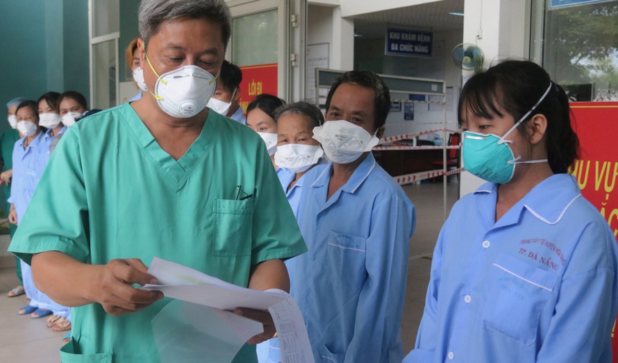 Thứ trưởng Bộ Y tế Nguyễn Trường Sơn trao giấy tờ ra viện cho bệnh nhân COVID-19 được chữa khỏi tại bệnh viện dã chiến Hoà Vang. Ảnh: Nguyễn Thành