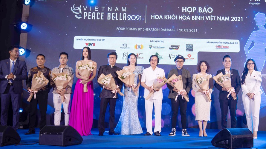 Hoa hậu Việt Nam Trần Tiểu Vy cùng các thành viên ban giám khảo, cố vấn...nhận hoa của ban tổ chức cuộc thi. 