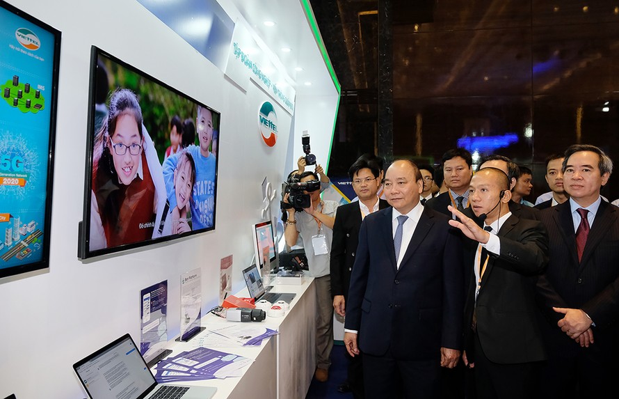 Thủ tướng Nguyễn Xuân Phúc và Trưởng Ban Kinh tế Trung ương Nguyễn Văn Bình xem các gian hàng tại triển lãm quốc tế về công nghiệp 4.0, hồi tháng 7/2018 