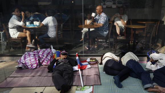 Những người biểu tình chống chính phủ ngủ trước một cửa hàng cafe ở Bangkok