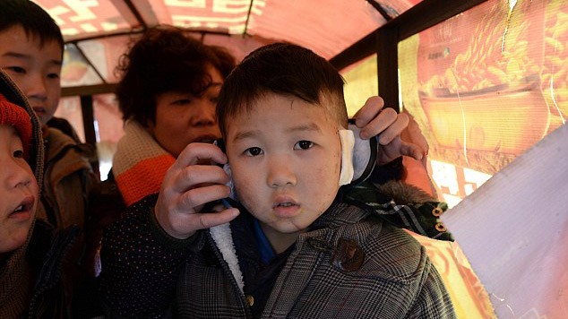 Cậu bé Wang Yufan trên đường trở về nhà sau khi nối lại tai ở viện