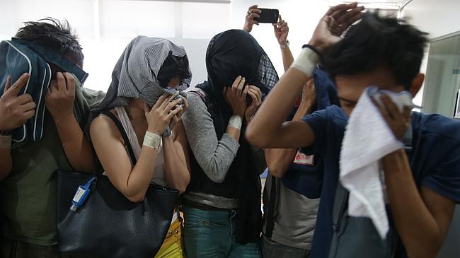 Những kẻ tham gia hoạt động khiêu dâm trẻ em che mặt tại cơ quan điều tra tội phạm mạng thuộc Cục Điều tra Quốc gia Philippines