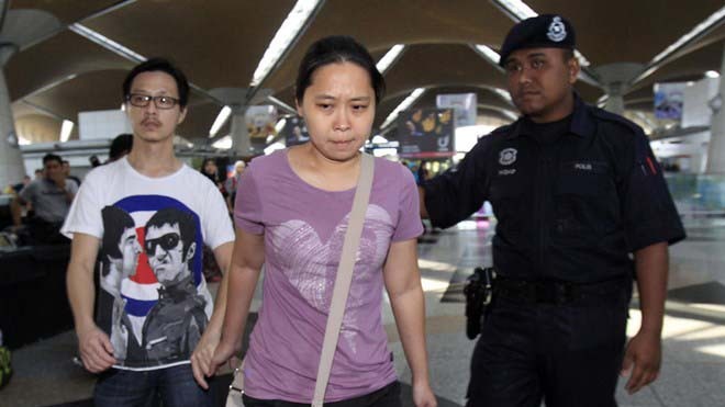 Các nhân viên an ninh ở sân bay Malaysia hướng dẫn cho các thân nhân của hành khách trên chuyến bay mất tích 