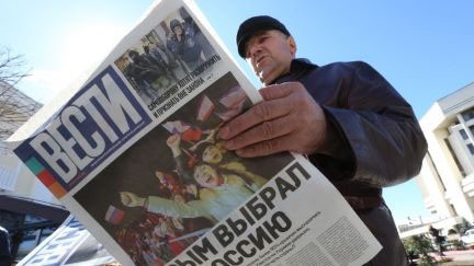 Một người đàn ông đọc tờ báo có tựa đề "Crimea chọn Nga" ở Simferopol, Crimea