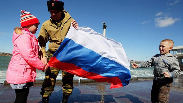 Một người đàn ông cùng 2 em nhỏ cầm cờ Nga ở Sevastopol, Crimea