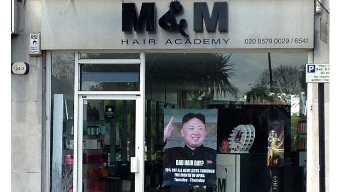 Tấm poster khuyến mại in hình lãnh đạo Triều Tiên Kim Jong Un treo trước cửa hàng tạo mẫu tóc M&M