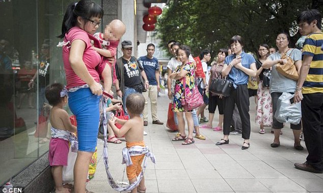 Người mẹ trẻ đem 3 con trai đi cho trên phố ở Trung Quốc