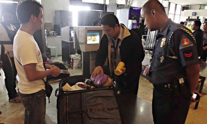 Kiểm tra hành lý hành khách tại sân bay Ninoy Aquino. Ảnh: Inquirer.