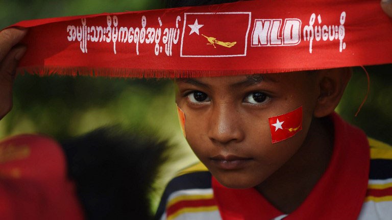 Một em bé đeo băng đỏ ủng hộ bà Aung San Suu Kyi, lãnh đạo NLD, tại điểm bầu cử.