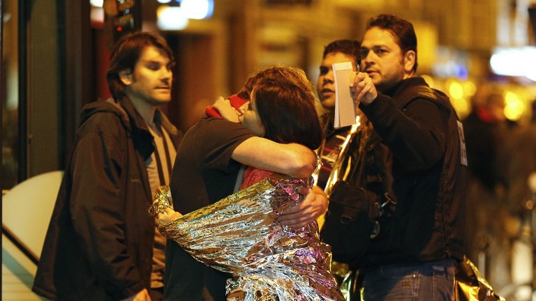 Vụ khủng bố kinh hoàng ở Paris tối ngày 13/11 khiến hàng trăm thương vong. Trong ảnh: Cảnh sát sơ tán hai người sống sót sau vụ khủng bố. 