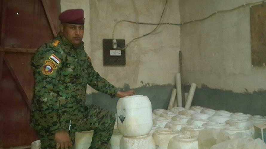 Binh sỹ Iraq bên cạnh những thùng trắng chứa vũ khí hóa học của IS