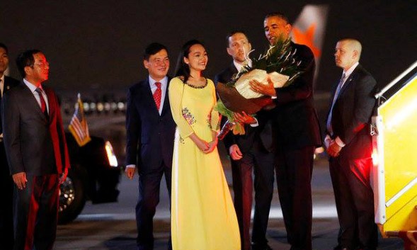 Tống thống Obama nhận hoa từ nữ sinh Việt khi đặt chân xuống sân bay Nội Bài. Ảnh: Reuters.