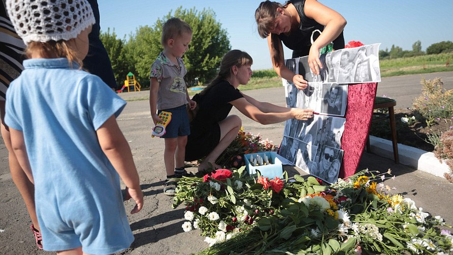 Dân làng đặt di ảnh một số hành khách xấu số của MH17 tại một khu tưởng niệm ở làng Petropavlivka, Donetsk, Ukraine