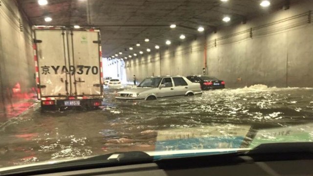 Xe cộ ngập trong nước tại một đường hầm ở Bắc Kinh hôm 20/7