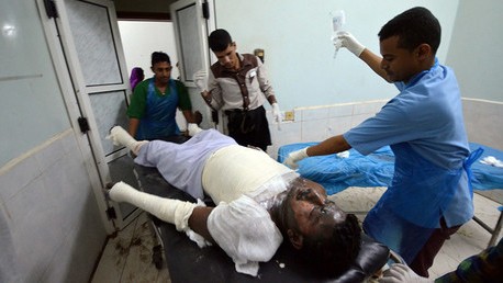 Các nhân viên y tế cấp cứu một nạn nhân của vụ không kích nhà tù ở Hodeidah, Yemen. 