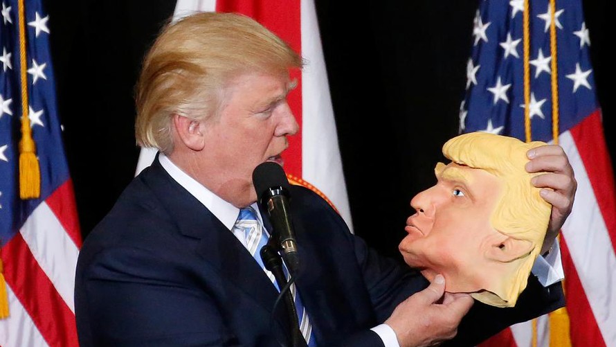 Ông Donald Trump, ứng viên đảng Cộng hòa, cầm trên tay chiếc mặt nạ hình ông tại điểm vận động tranh cử ở Sarasota, Florida tối ngày 7/11 (giờ địa phương).