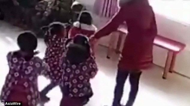 Hai bé gái đang múa thì giáo viên lôi ra khỏi đội hình.