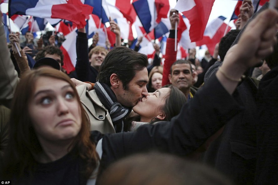 Một cặp đôi hôn nhau giữa rừng cờ hoa ở thủ đô Paris, Pháp sau khi biết tin ông Emmanuel Macron giành chiến thắng