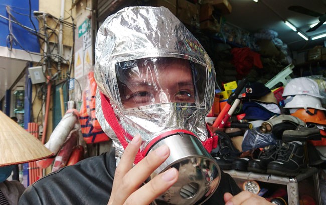 Một người dân đang thử mặt nạ chống khói trên phố Yết Kiêu.