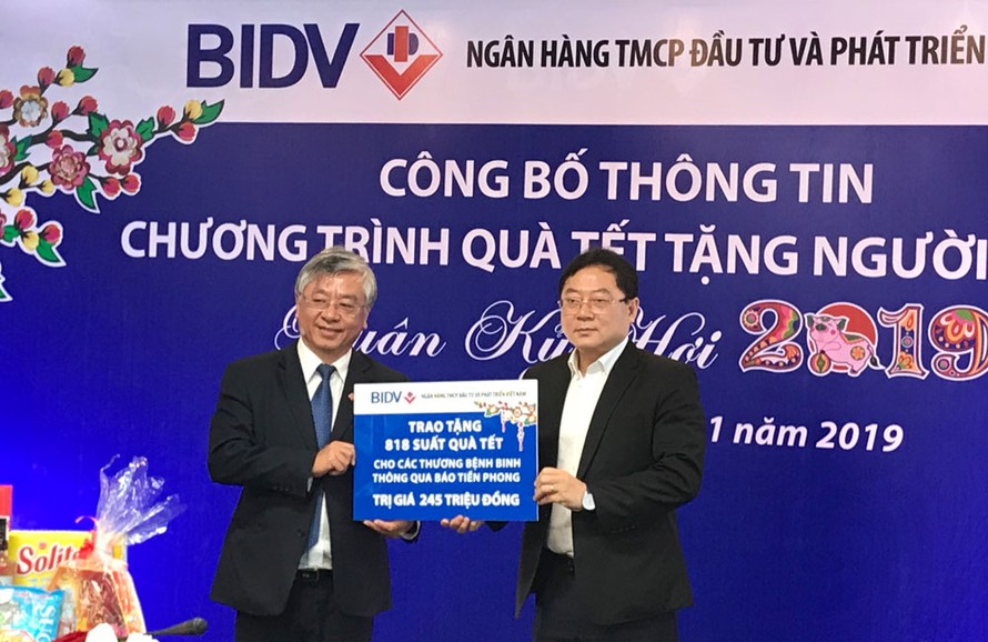 Tổng Biên tập báo Tiền Phong Lê Xuân Sơn (phải) nhận những phần quà từ BIDV để trao cho người nghèo dịp Tết. Ảnh PV