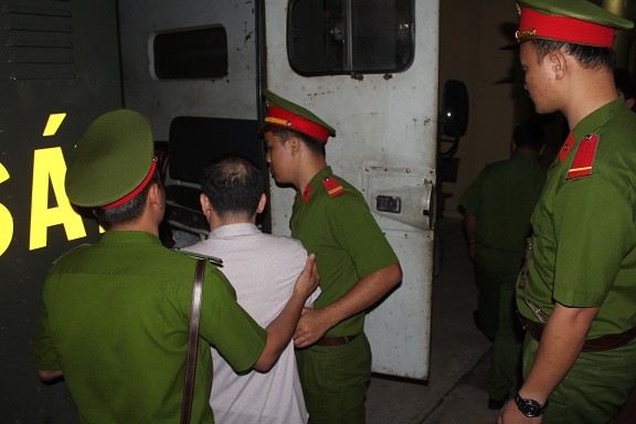 Cảnh sát áp giải bị cáo Lương Văn Thảo lên xe thùng.