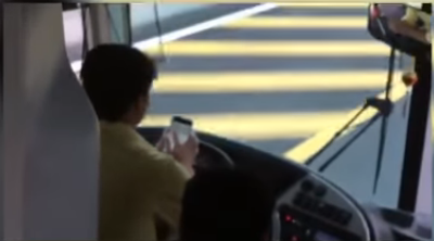 Lái xe vừa điều khiển xe trên cao tốc vừa xem điện thoại.