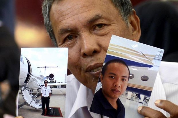 Ông Selamat Omar và bức hình kỹ sư Mohd Khairul Amri Selamat. Ảnh: The Star