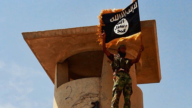 ISIS giơ cờ chiến thắng sau khi chiếm giữ một trạm kiểm soát quân sự tại miền bắc Iraq (Ảnh: RT)
