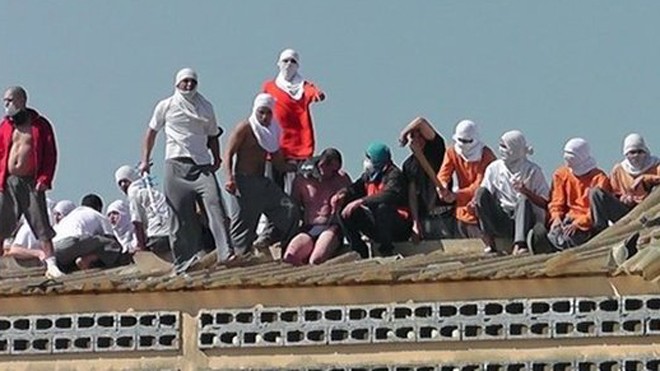 Các tù nhân nổi loạn trên mái nhà chờ đàm phán để kết thúc bạo lực (Ảnh:BBC)