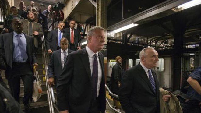 Thị trưởng New York Bill de Blasio (trái) đi tàu điện ngầm tới cuộc họp báo nhanh trấn an người dân. Ảnh: Reuters