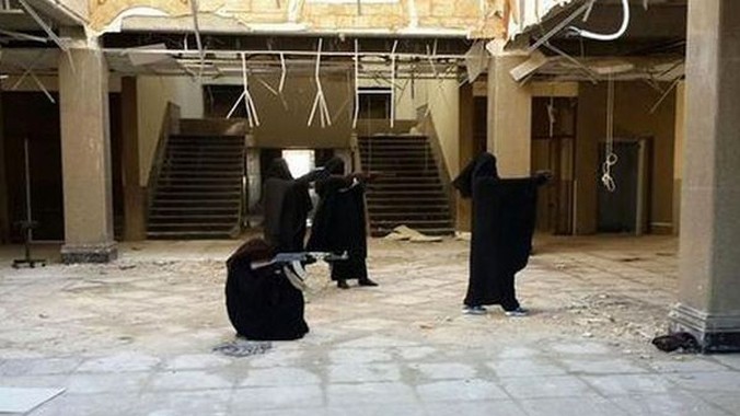 Hình ảnh 4 cô gái mặc đồ đen che kín mặt đang tập bắn súng được đăng tải trên Twitter. Ảnh: Telegraph
