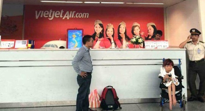 Chị Vân (ngồi xe lăn, ở giữa) ngồi chờ ở sân bay Đà Nẵng. Ảnh: Vietnamnet