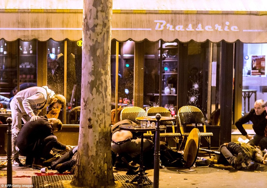 Người chết và bị thương nằm trên vỉa hè bên ngoài quán cà phê Bonne Biere ở Paris sau một loạt các cuộc tấn công vào thứ Sáu. Ảnh: Dailymail